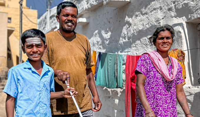 A happy visually impaired father walks with his son and wife. 